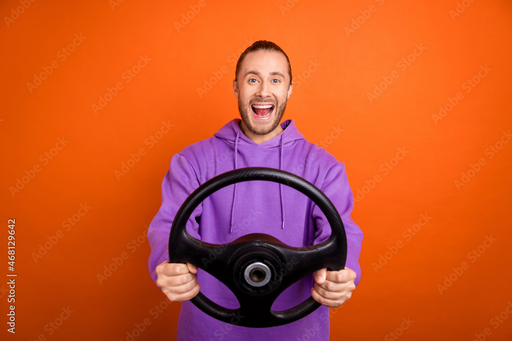 Sticker Photo of funny millennial brown tail hairdo guy drive car wear purple sweatshirt isolated on orange color background