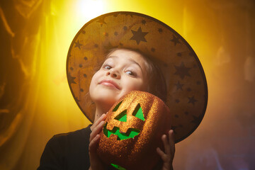 Cute little girl in costume for witch in the room decorated fot Halloween