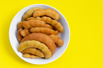 Tamarind pickled fermented in white bowl on yellow background.