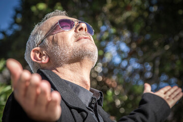 relaxed man in sunglasses breathing outdoors