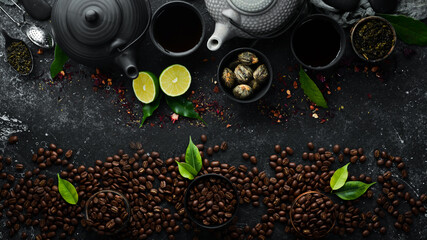 Coffee and tea banner. Aromatic coffee beans and tea leaves in cups with teapot. Traditional drinks on a black stone background. Top view.