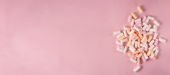 Top view of sweet soft marshmallows on the bright pink surface.Empty space