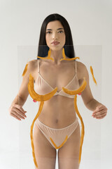 Fototapeta premium Woman holding transparent glass with drawing contours of the figure in front of her body