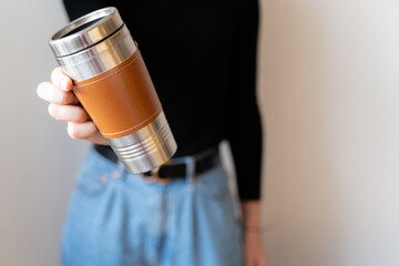 Woman in black shirt holding thermo mug.