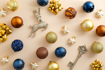 Christmas composition. Beige Christmas background with with golden, bronze, blue baubles...