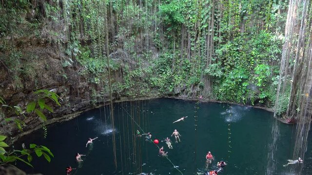 Tourists are swimming in the  Ik Kil Cenote. Tinum Municipality, Yucatan, Mexico