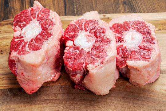 Three pieces of fresh juicy ox tail on a wooden cutting board. Premium quality beef product. Meat industry. Butcher craft and skill concept