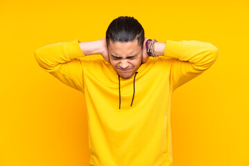Asian handsome man isolated on yellow background in back position and looking side