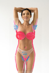Fototapeta premium Woman smiling while posing over glass with drawing hairy unshaven female armpits