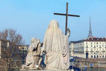 Religious sculpture in Turin . Sculpture of Gran Madre Church . Chiesa della Gran Madre di Dio . Marble statue with wooden cross - obrazy, fototapety, plakaty