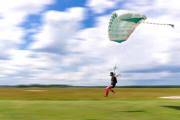 Skydiver landing on a high perfomance canopy - obrazy, fototapety, plakaty