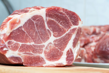 Close-up of a large fresh beautiful piece of pork meat for cooking steak on a cutting board