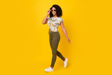 Fototapeta na wymiar Full length profile side photo of young african lady go hand touch eyeglasses isolated over yellow color background