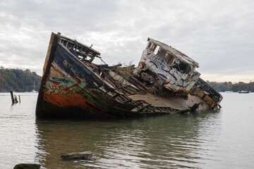 Carcasse d'un vieux bateau de pêche rouillé abandonné et échoué sur le rivage. épave dans un cimetière de bateaux.