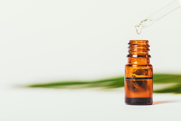 Drop organic essential oil drips into dark glass bottle