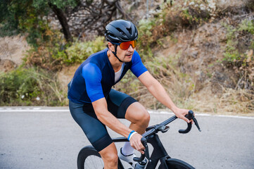 Cyclist riding up a mountain pass on a road