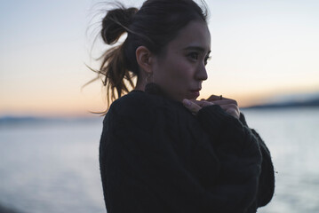 Fototapeta premium 夕暮れの海を散策するクールな女性