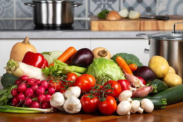 A set of organic vegetables on the kitchen table and a stove in the background