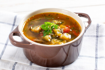 Soup with lentils and vegetables on a light table.