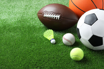 Set of different sport balls and shuttlecock on green grass. Space for text