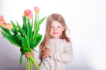 Beautiful happy girl child holding a bouquet of colorful tulip flowers on white background.
