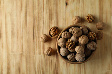 Walnuts in wooden bowl on wooden background