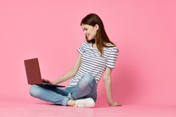 woman sitting on floor with laptop online shopping shopping technology pink background