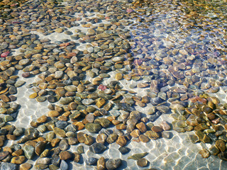 Colorful stones under water, with water effect over them.