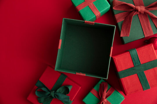 Open Festive Christmas Present Box On A Red Background. Flat Lay, Top View