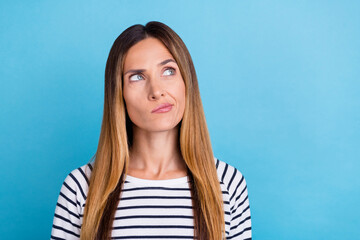 Photo of young blond unsure lady look up wear striped shirt isolated on blue color background