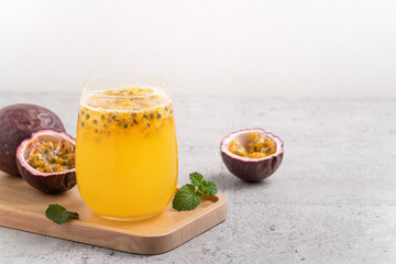 Delicious juicy passion fruit with sparkling juice on gray table background.