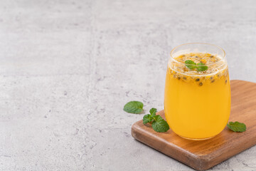 Delicious juicy passion fruit with sparkling juice on gray table background.