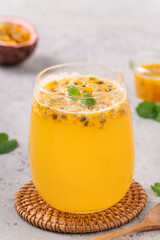 Delicious juicy passion fruit with sparkling juice on gray table background.