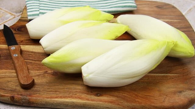 plusieurs endives crues sur une planche &agrave; d&eacute;couper