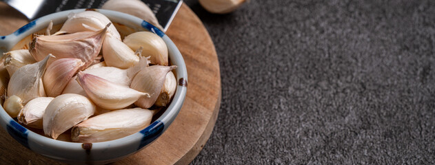 Fresh garlic cloves on black table background.