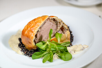 meatloaf in dough on a white plate with microgreen
