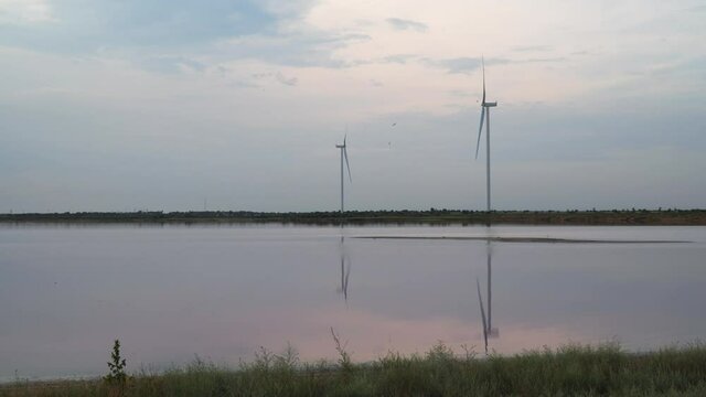 Wind turbines on the shore of the lake. Lake Lemuria (Pink Lake) is a lake in the Kherson region of Ukraine. Evening time