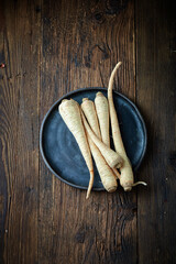 Raw Organic Parsley Roots on a wooden background. Free space for your text.