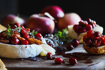 Baked Camembert Brie cheese with a cranberry, honey, balsamic vinegar and nut relish and garnished...