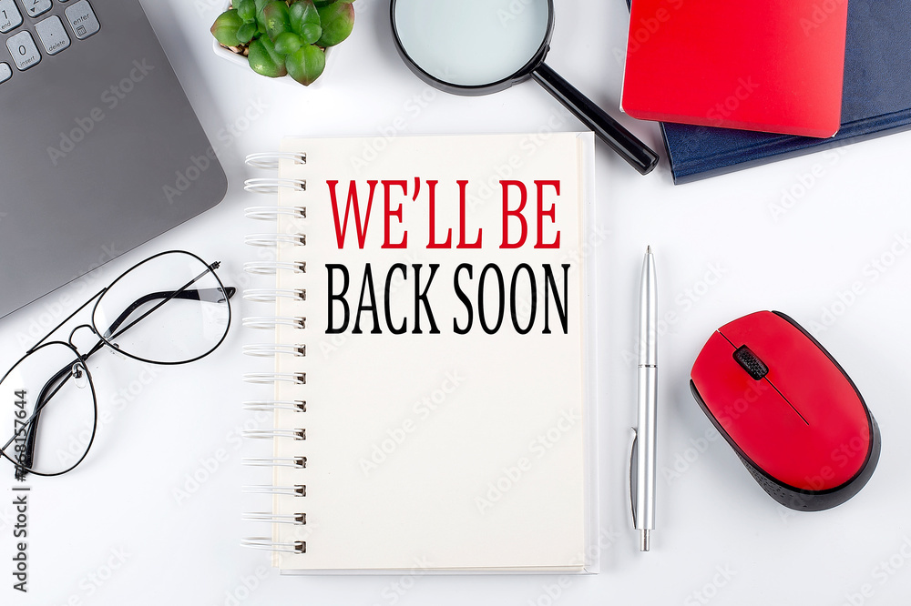 Poster we'll be back soon text on a notepad with laptop on the white background