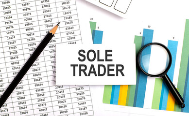 Obraz premium SOLE TRADER text on white card on chart background