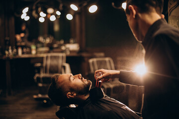Handsome man at barbershop shaving beard