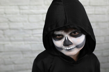 niño con disfraz de muerte, con capucha guadaña y maquillaje - 468158817