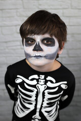 niño con disfraz de esqueleto con la cara pintada