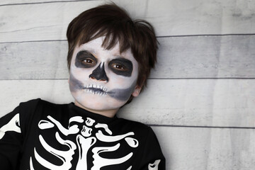 niño con disfraz de esqueleto con la cara pintada - 468158832