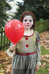niño disfrazado de payaso malvado con globo rojo