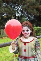 niño disfrazado de payaso malvado con globo rojo - 468158843