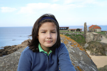 niño feliz con pelo largo posando cerca de la playa en Galicia - 468158868
