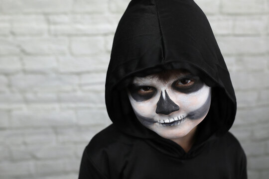 ni&ntilde;o con disfraz de muerte, con capucha guada&ntilde;a y maquillaje