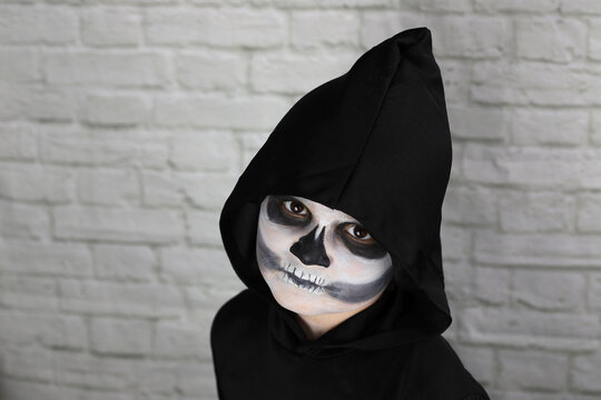 ni&ntilde;o con disfraz de muerte, con capucha guada&ntilde;a y maquillaje